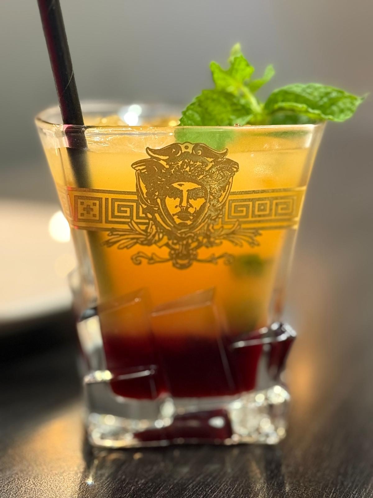 Layered drink in a gold-etched glass