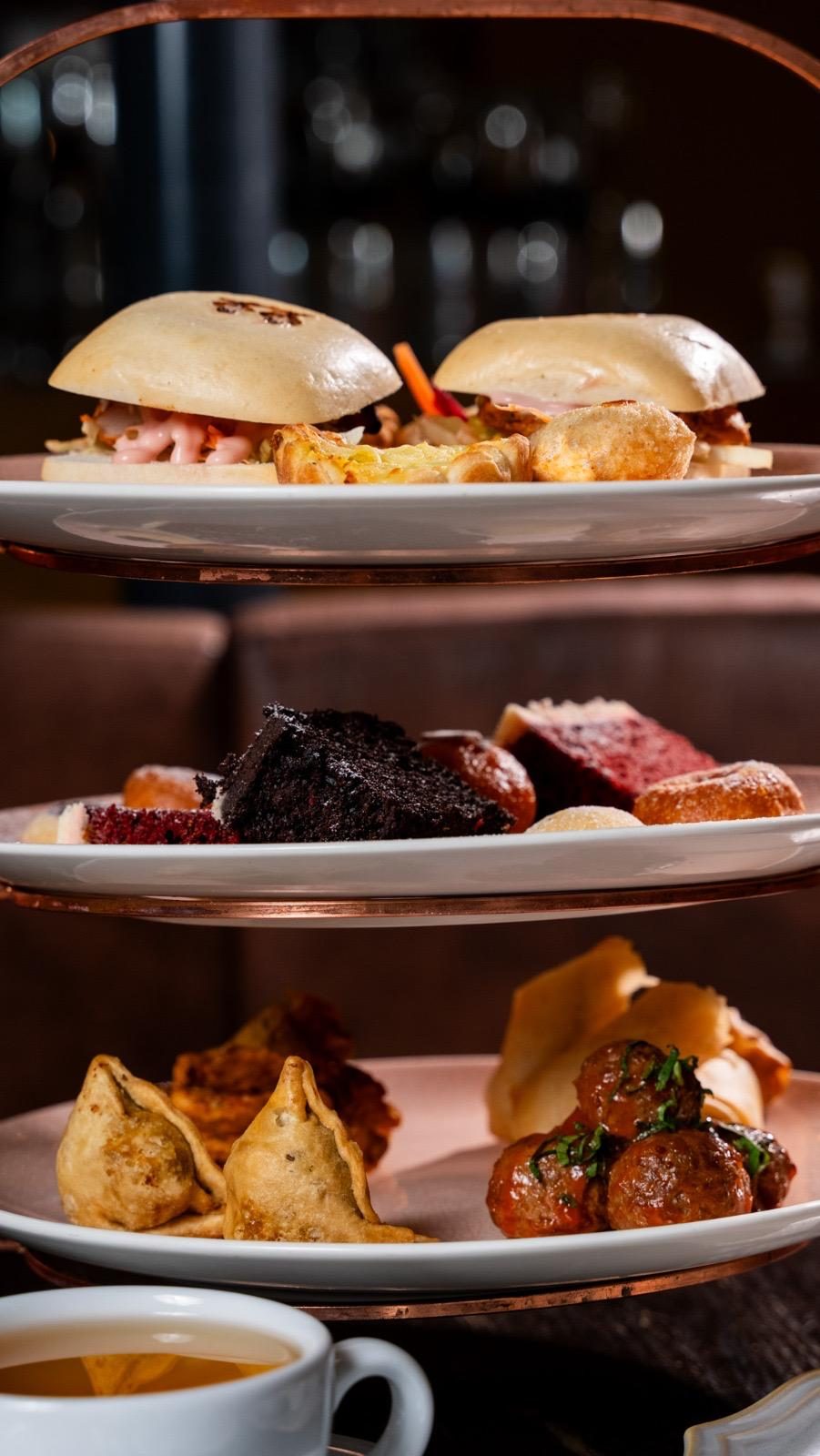 Tiered stand with bao buns, brownies and samosas